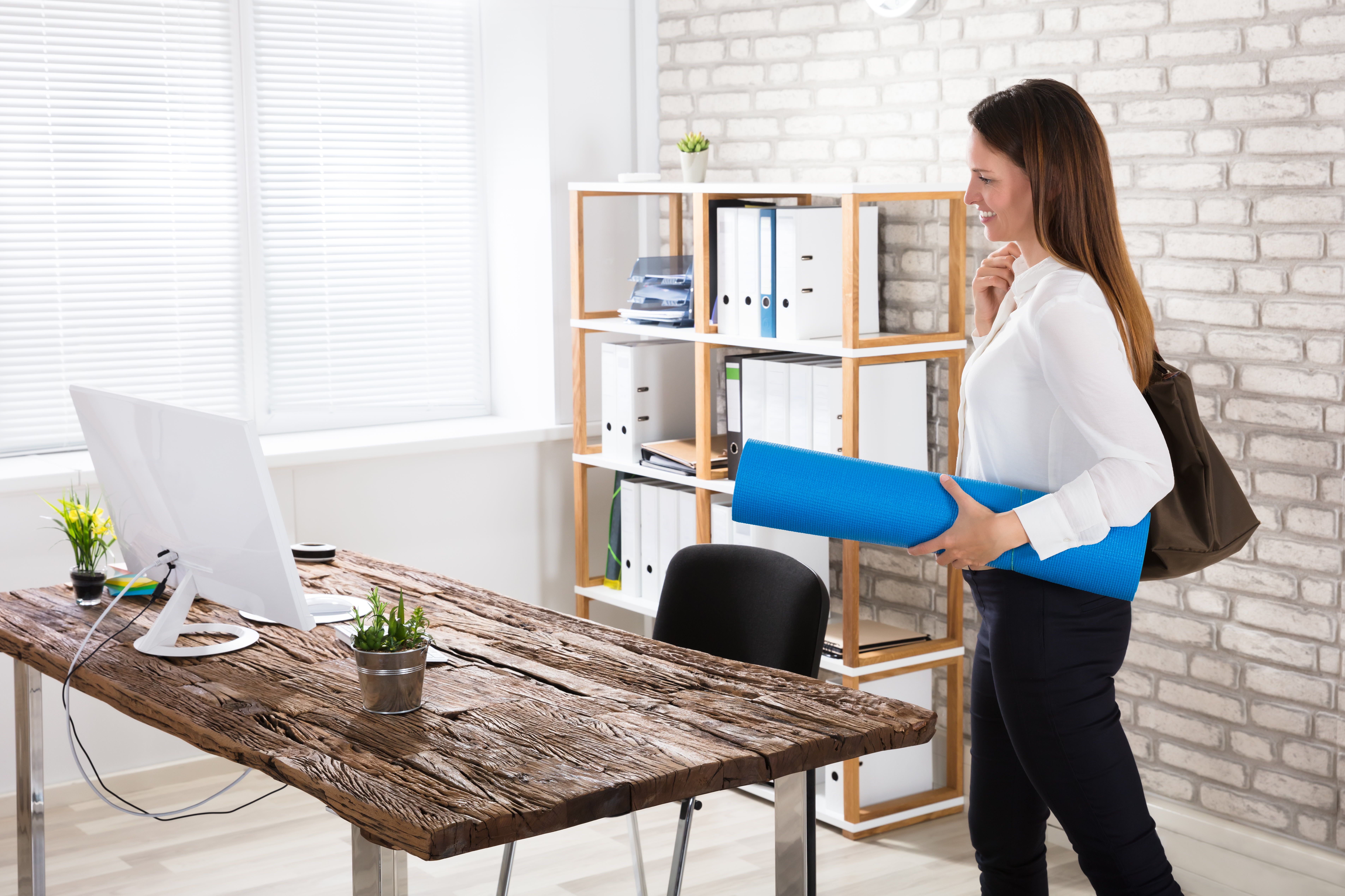 Businesswoman Walking In Office With Exercise Mat